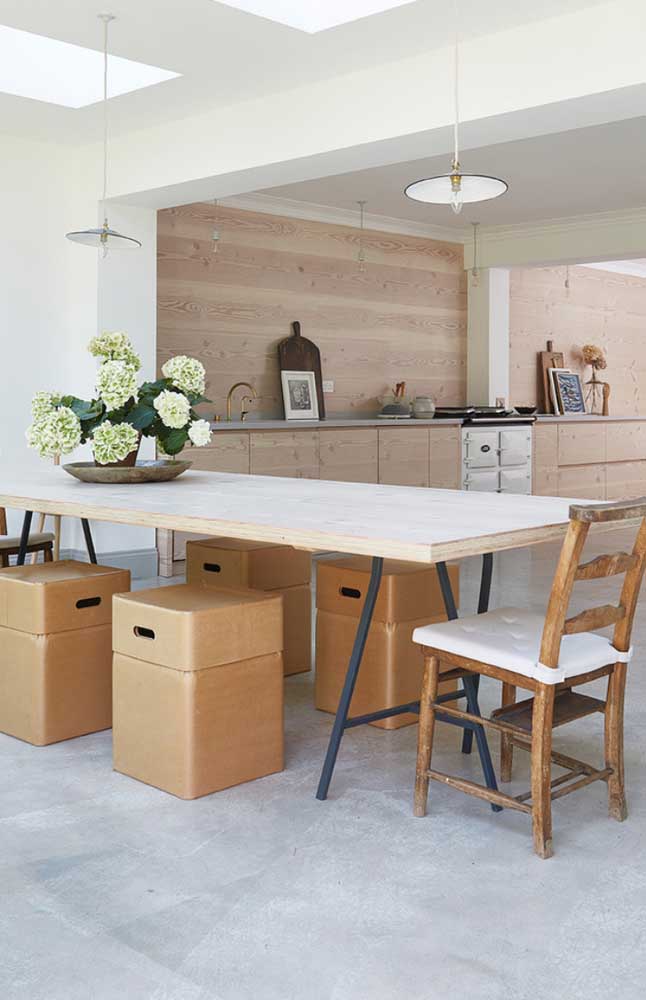 La cuisine et la salle à manger intégrée misent sur la combinaison du blanc et du bois pour obtenir un décor épuré et en même temps cosy