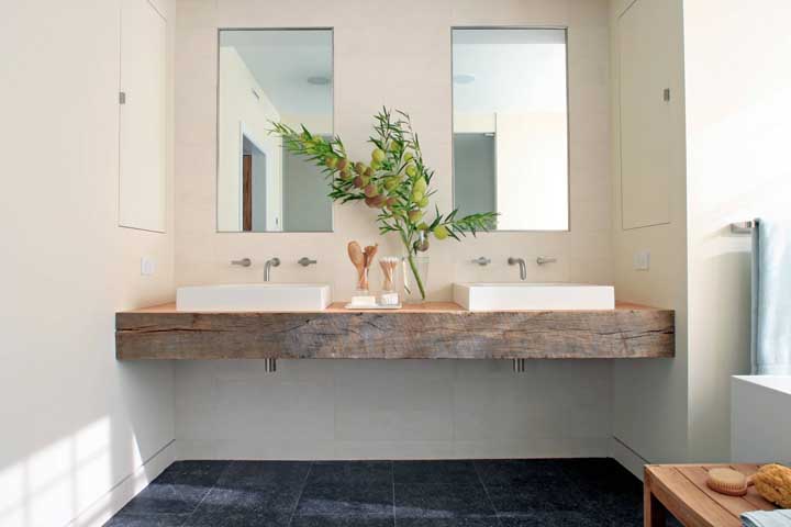 Élégante salle de bain blanche contrastée par la rusticité du comptoir en bois de démolition