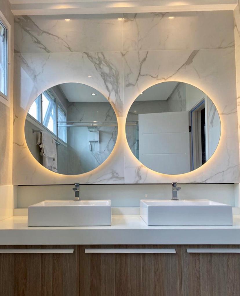 miroir rond éclairé dans la salle de bain avec revêtement en marbre