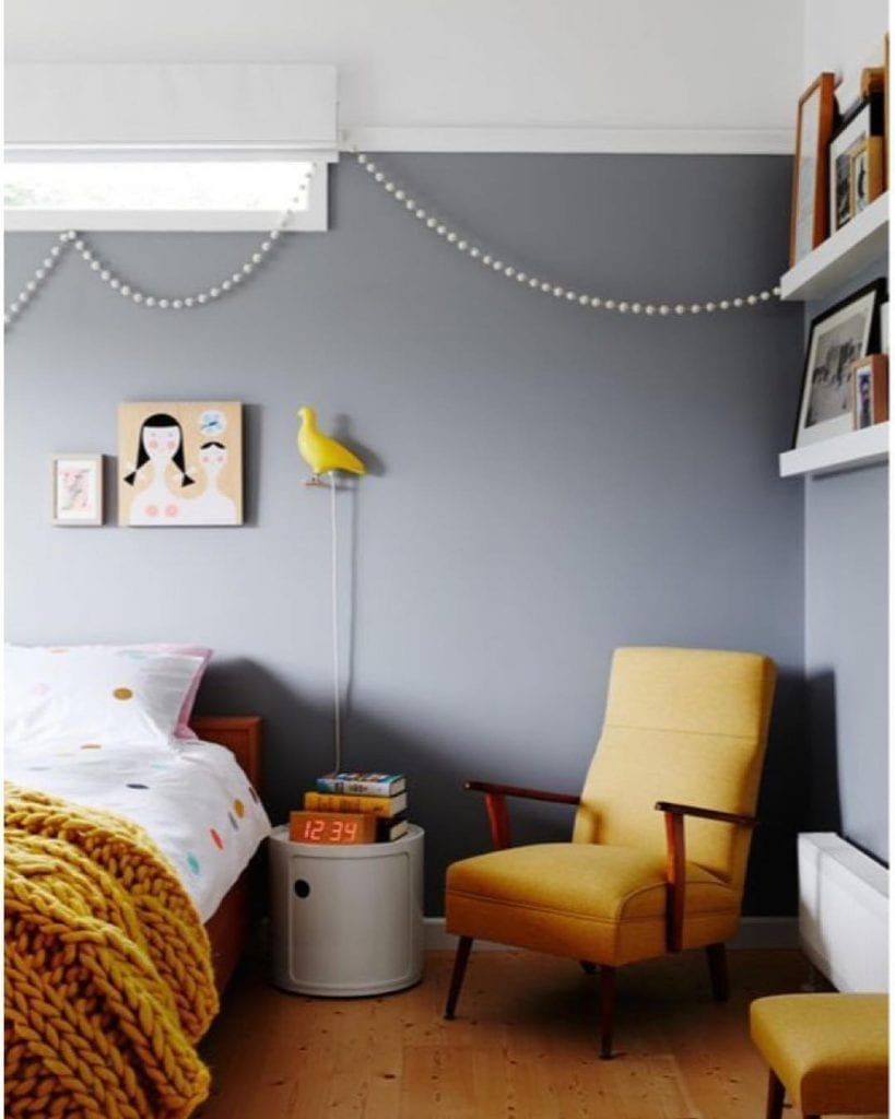 Chambre inantil avec mur gris et fauteuil jaune moutarde