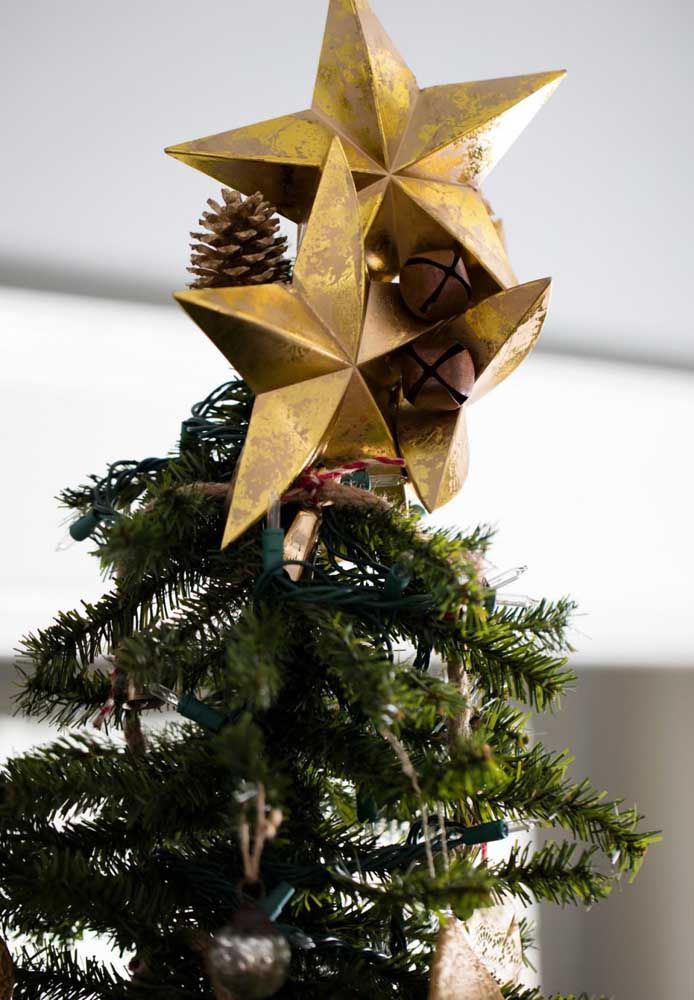 Étoile de papier avec des pommes de pin sur la cime de l'arbre