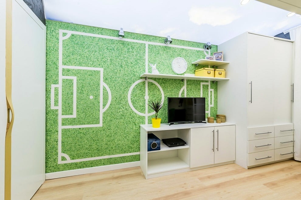En choisissant la couleur verte du papier peint liquide et en collant des rayures blanches dessus, vous pouvez obtenir un vrai terrain de football à la maison