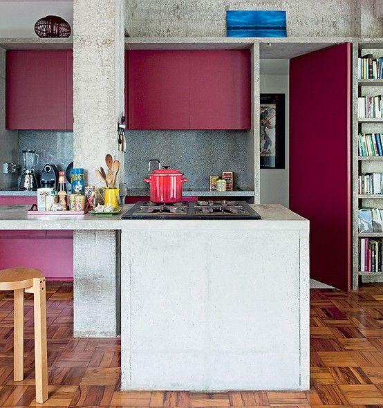 La cuisine en béton se marie avec un peu de couleur dans la pièce