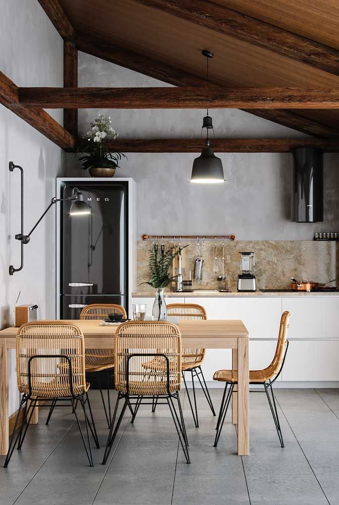 Intégration entre les styles et les matériaux: dans cette salle à manger, le bois de la table à manger s'aligne avec les chaises design modernes en fibre naturelle et en fer