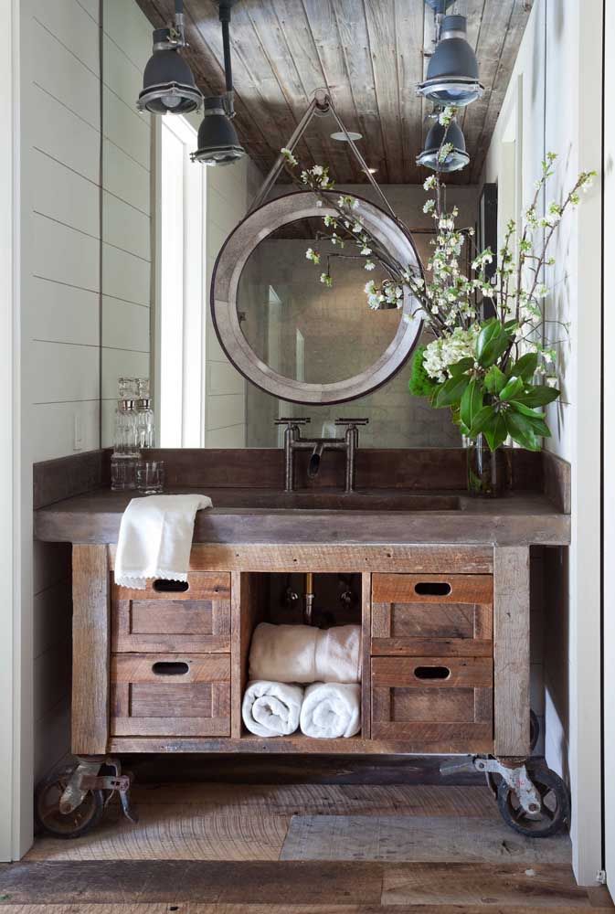 La salle de bain de la maison mérite également toute l'attention lors de la décoration;  celui-ci, par exemple, a remporté un banc en bois rustique avec jusqu'à des roues en fer
