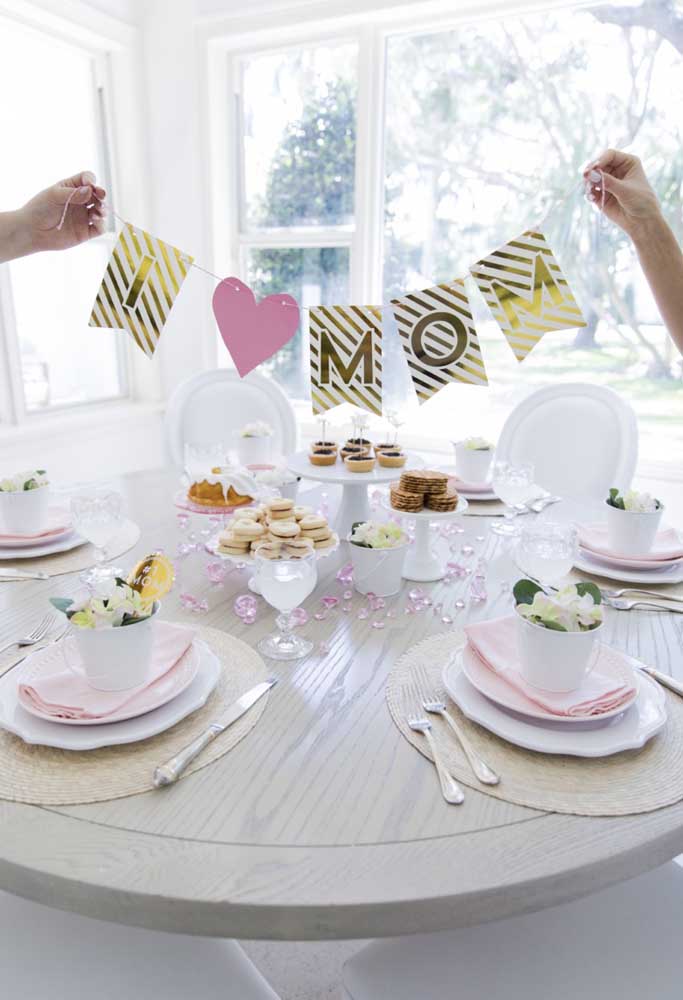 Pour décorer la table de la fête des mères, étalez des cristaux, placez les friandises sur des plateaux et accrochez une pancarte.