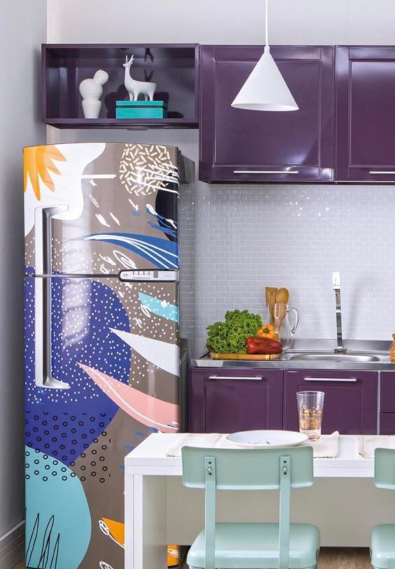 Cette cuisine aux couleurs vives a reçu un réfrigérateur enveloppé de formes abstraites