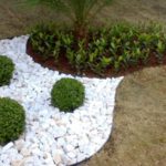 jardim com pedra portuguesa branca e arbustos