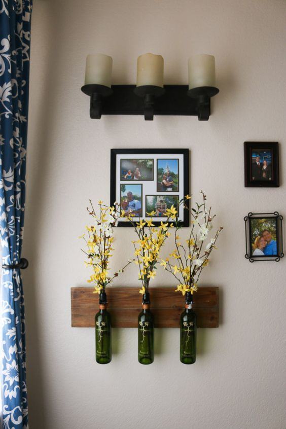Pots de fleurs en verre attachés à un support en bois.