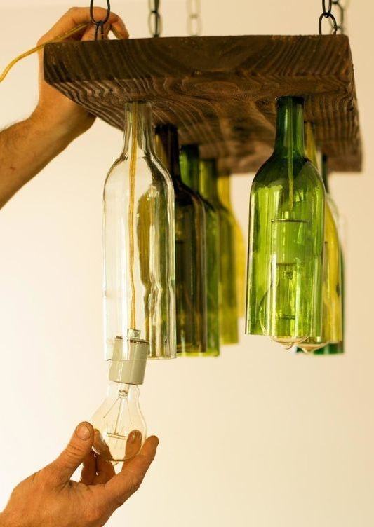 Lampe en bois et bouteilles en verre suspendues.