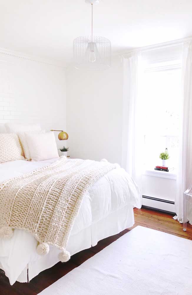La chambre propre et lumineuse dispose d'une petite couverture en tricot géant pour recouvrir le lit