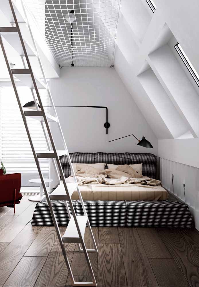 La chambre à fond blanc mise sur un lit à carreaux en cuivre;  mettre en valeur le fauteuil rouge sur le côté qui rompt la dualité chromatique