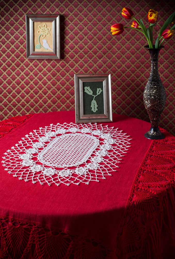 Le centre de table au crochet blanc contraste parfaitement avec la nappe rouge.