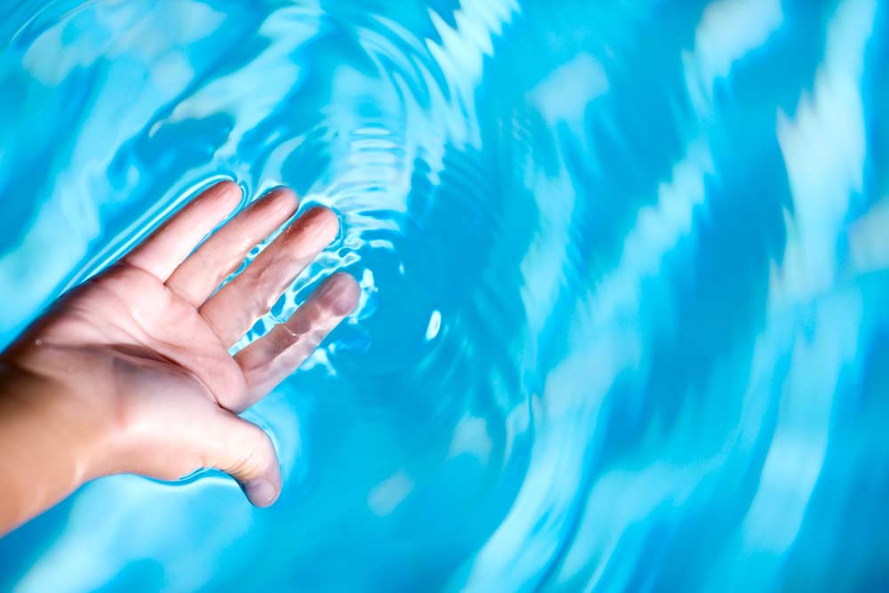 Comment nettoyer une piscine: les mains dans l'eau