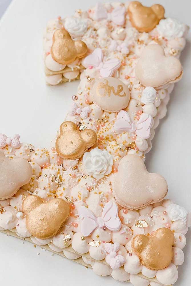 Gâteau Minnie pour une fête d'un an.  Pour la décoration, des biscuits en forme de personnage, ainsi que des fleurs et des rubans 