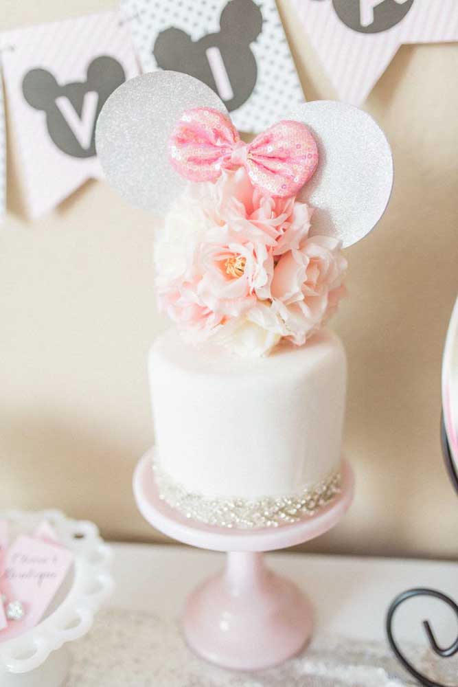 Un gâteau Minnie super délicat et romantique dans les tons de blanc et de rose décoré de mini perles et de fleurs