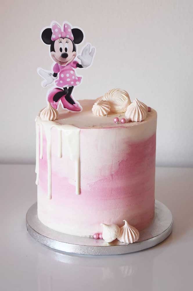 Gâteau Minnie spatulé en blanc et rose.  Le toten du personnage décore le dessus