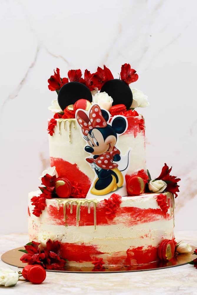 Le rouge du personnage apparaît dans ce gâteau dans les fleurs, la chantilly et les bonbons