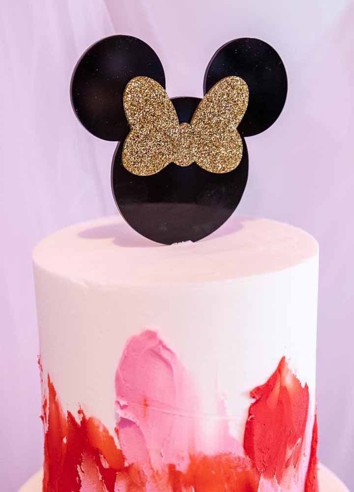 Gâteau spatulé aux couleurs du personnage;  sur le dessus du gâteau, Minnie apparaît avec un nœud doré brillant